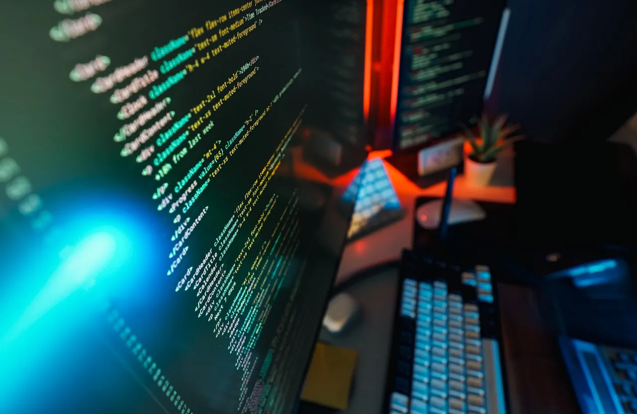 Code displayed on a computer screen with ambient blue and red lighting